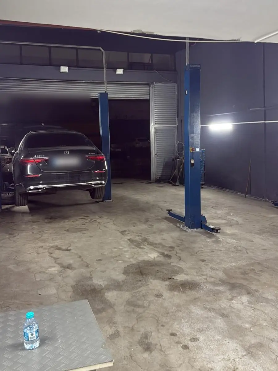 İki sütunlu lift ve arkada bakıma alınmış Mercedes E-Serisi